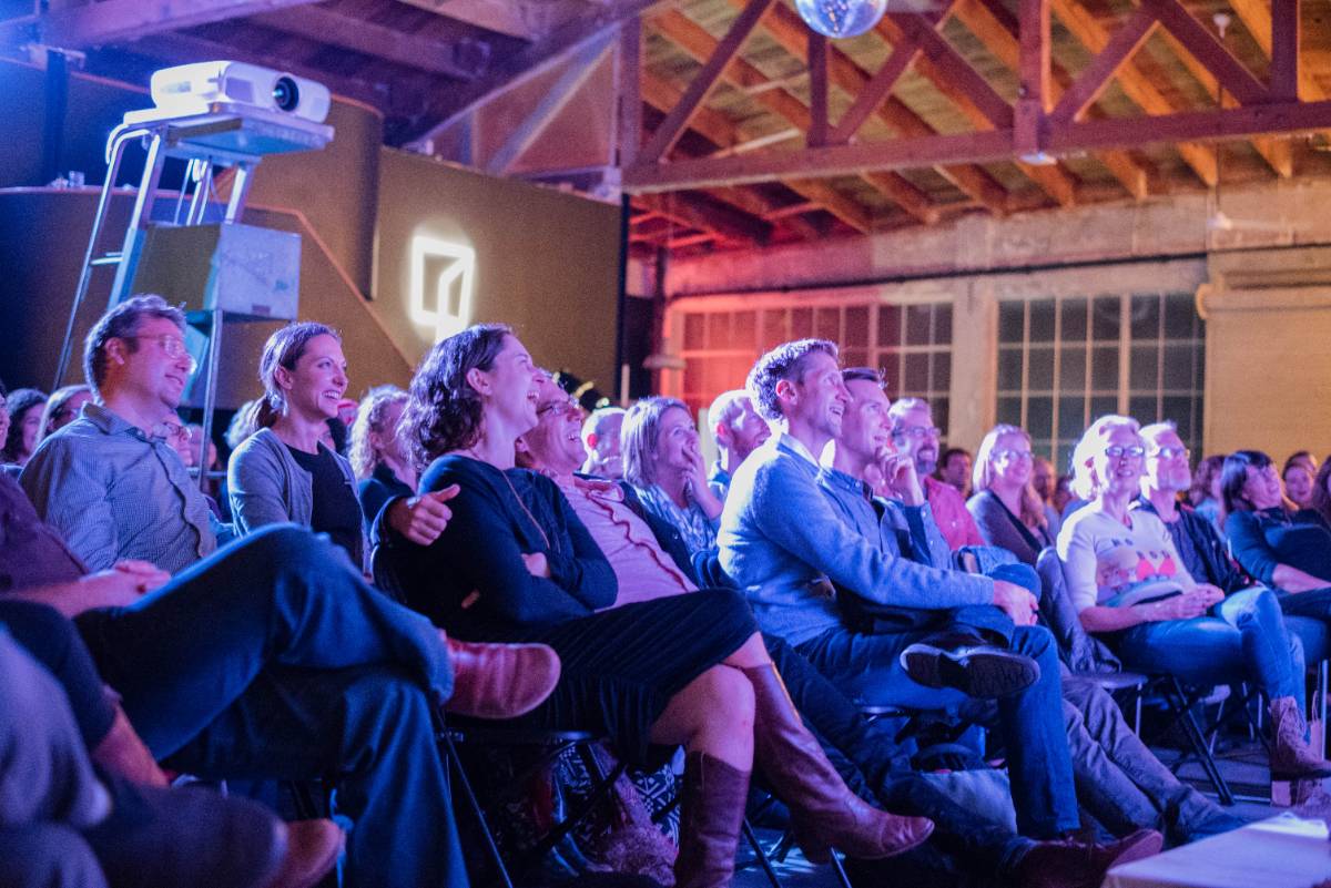 A storyteller on stage at a Reimagine bookstore gathering